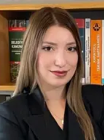 Lawyer posing confidently in front of legal books on a shelf at a law office.