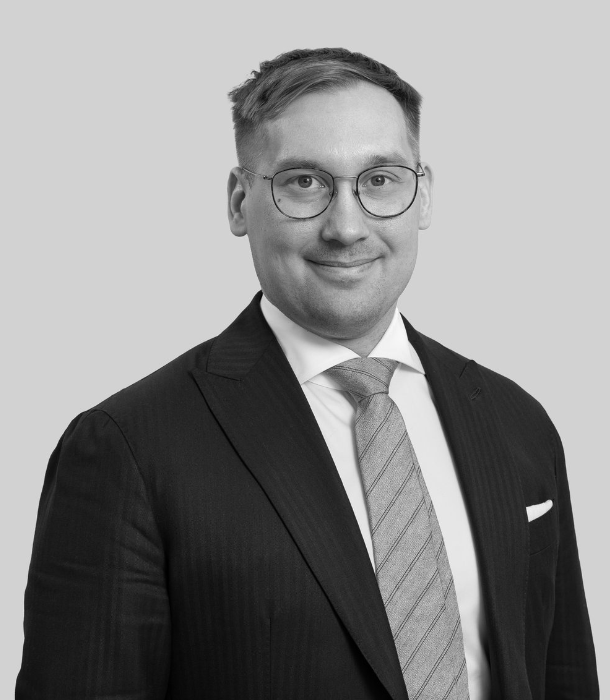 Lawyer in business attire smiling, posing for professional portrait with neutral background.