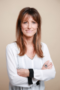 Lawyer posing with arms crossed, smiling at the camera against a neutral background.