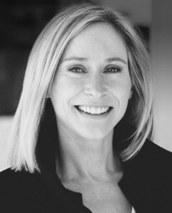 Professional woman smiling, wearing a dark jacket, in a neutral background, suggesting a business or legal setting.