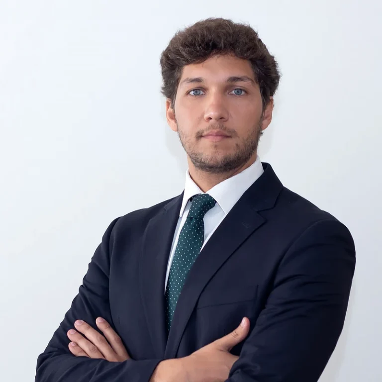 Lawyer posing confidently with arms crossed against a neutral background.
