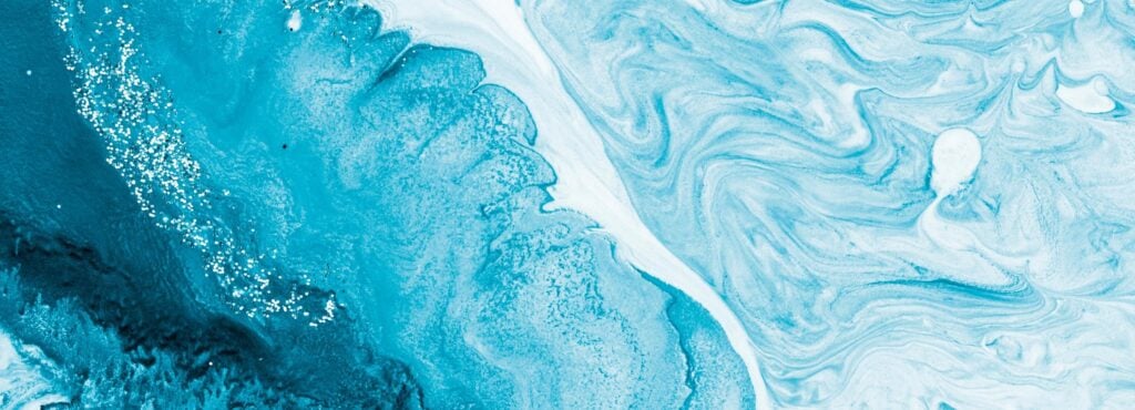 Abstract blue and white marbled background with fluid patterns, resembling ocean waves or a tranquil water surface.