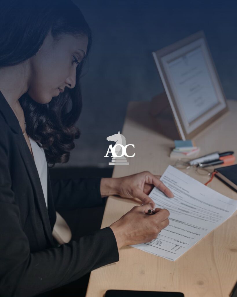 Lawyer reviewing and signing legal documents at an office desk.