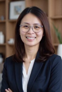 Legal professional smiling confidently in office setting, wearing glasses and professional attire.