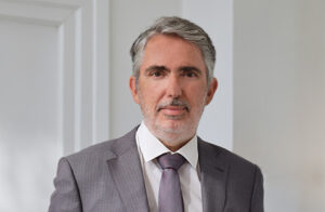 Lawyer in professional attire posing confidently in a modern office setting.