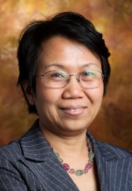 Professional woman smiling, wearing glasses and a suit, suitable for a legal or business context.