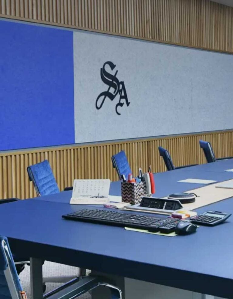 Modern conference room with blue table, chairs, and office supplies, suitable for legal meetings.