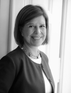Smiling female attorney standing by the window in a professional setting.