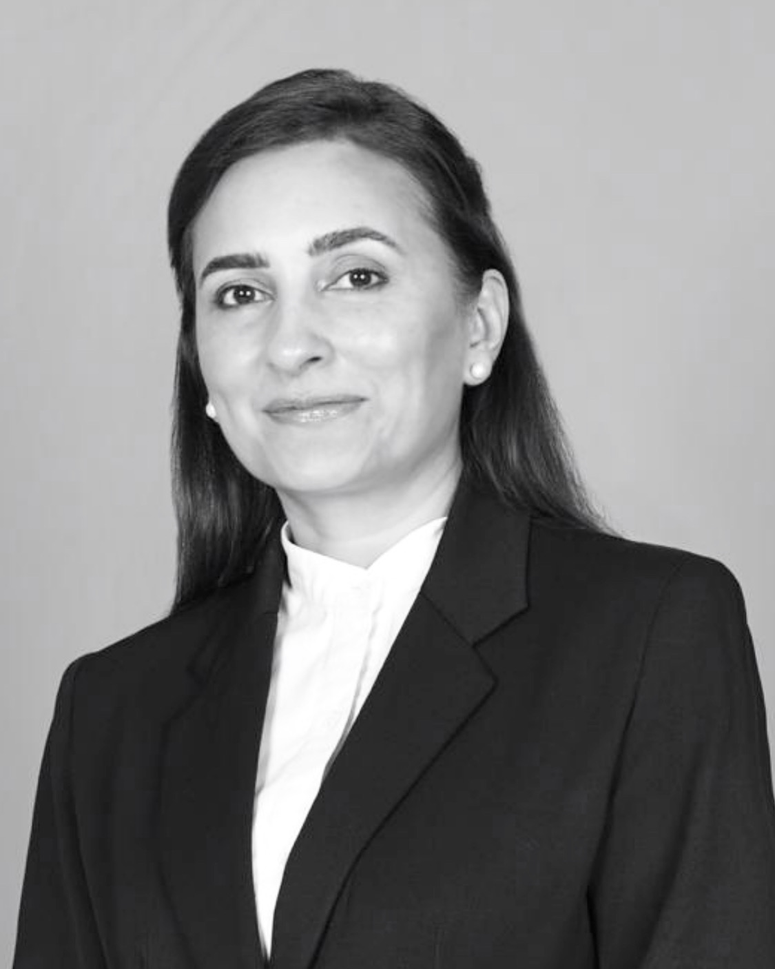 Lawyer in professional attire, smiling against a neutral background.