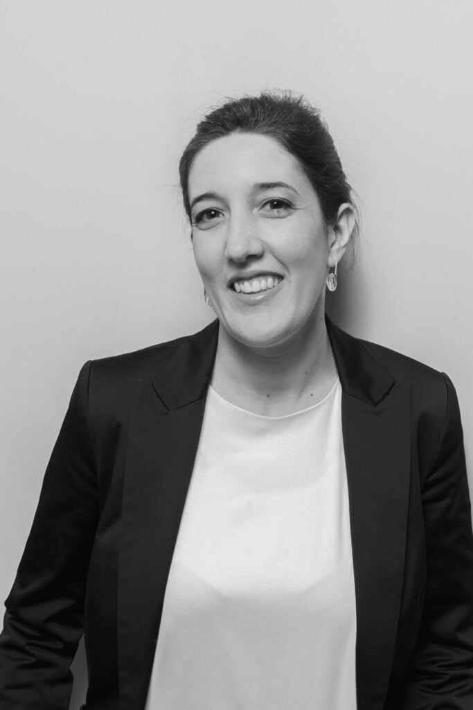 Legal professional smiling while wearing a black blazer, set against a plain background.
