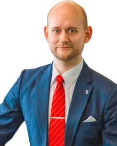 Lawyer in a blue suit and red tie, confidently posing with a slight smile against a neutral background.