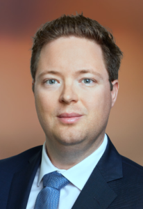Professional man in a suit, likely a lawyer, presenting a confident expression in front of a neutral background.