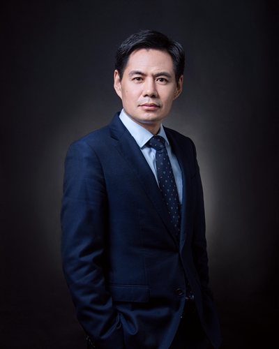 Attorney in a formal suit posing confidently against a dark background for a professional profile.
