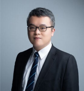 Lawyer in a professional suit, posing against a neutral background.