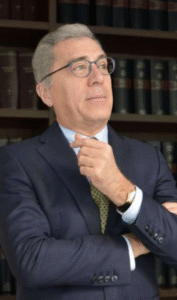 Attorney contemplating legal strategy in front of law books in an office setting.
