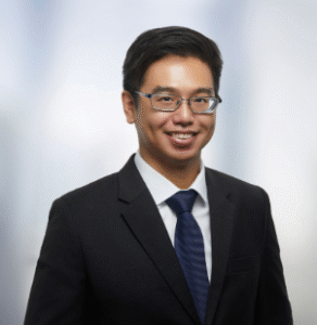 Attorney smiling in professional attire against a blurred background.