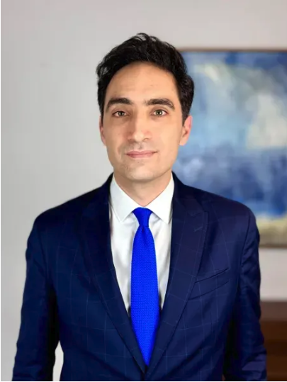 Lawyer In A Suit With A Blue Tie, Standing Confidently In A Professional Office Setting.