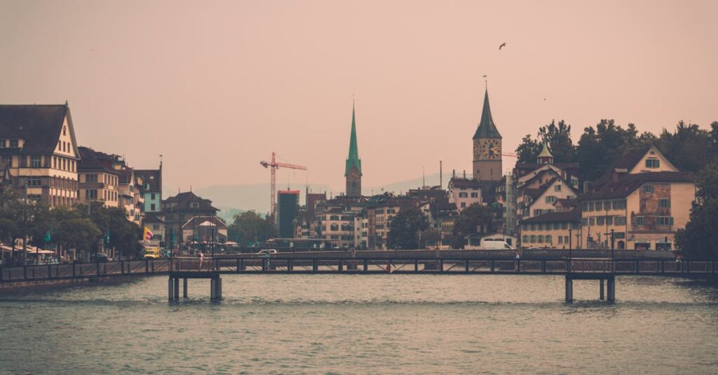 Cityscape featuring a waterfront view with historic buildings and church spires in a tranquil urban setting.