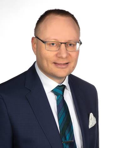 Lawyer in a suit and glasses, smiling against a white background.