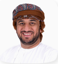 Smiling individual wearing traditional attire with a patterned headscarf, posing for a professional profile photo.