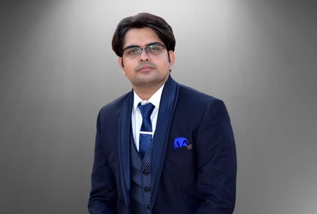 Lawyer In Formal Attire Sitting Against A Neutral Background.
